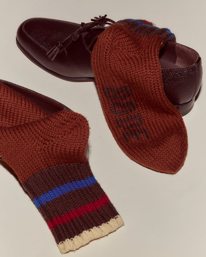Brown leather shoes with Herrington Stripe Socks - Brown draped over them, featuring blue and red stripes.