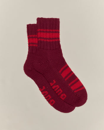 A pair of Herrington Stripe Socks - Burgundy, hand-knit in maroon with red stripes and 