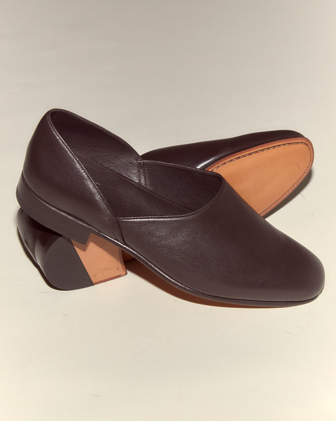 A pair of Leather House Shoes - Brown, crafted from Italian leather with low block heels, one shoe displayed on its side.