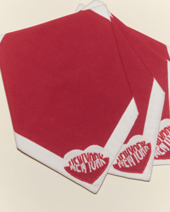 Three Heart Deco New York Cocktail Napkins in red and white cotton voile, each featuring a heart appliqué, are stacked on a light surface.