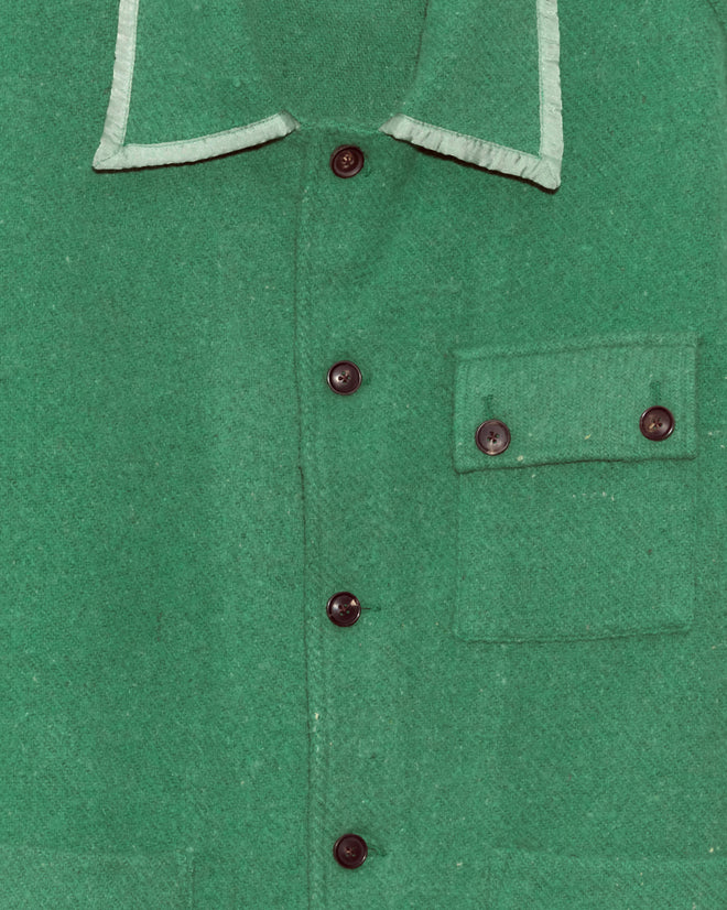 Close-up of the Island Mists Jacket - L: a green button-up with a pocket and light collar trim, inspired by classic midcentury wool jackets and uniquely crafted in New York.