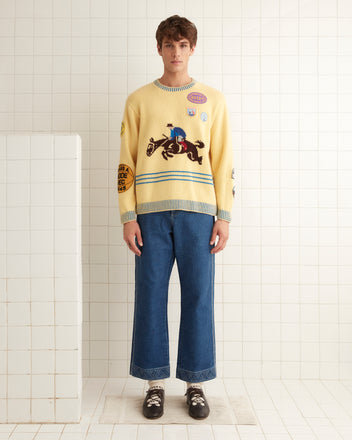 A person is wearing the lively Jockey Sweater from the 1980s, paired with blue jeans in a tiled room.