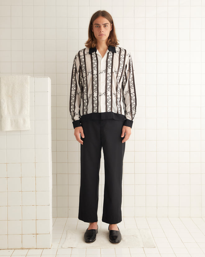 Black and white cotton shirt with black-and-white embroidered roses and stripes of satin ribbon. The shirt has a contrast collar and hem and an unfitted silhouette.