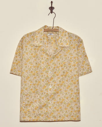 Lion's Mane Floral Shirt - M/L: yellow and white short-sleeve vintage button-up, displayed on a hook against a plain wall.
