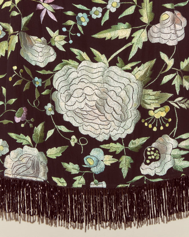 The Luna Rose Top - S features unique floral embroidery with white flowers and green leaves on dark fabric, finished with a fringe. Inspired by classic antique piano shawl designs.