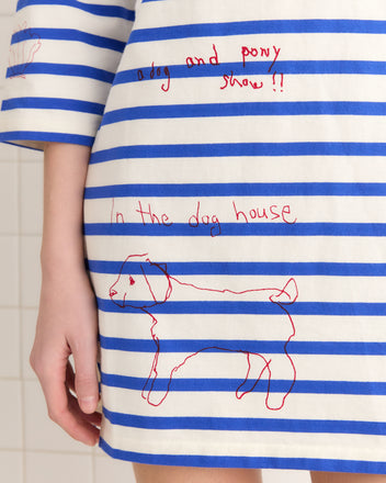 The Margate Dress is a French Navy striped cotton outfit, featuring vibrant red text 