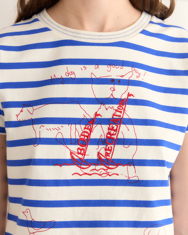 Someone wearing the Margate Sails Tee, a marinière-style shirt featuring cartoonish dog drawings and the text 