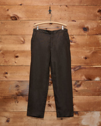 Lightweight Linen Side-Buckle Trousers in brown, displayed on a wooden hanger against a rustic wooden wall—these men’s summer trousers feature a stylish side-buckle design for a tailored fit.