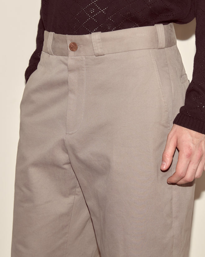 Person wearing Campus Trousers - Grey, made of heavyweight cotton twill, paired with a black sweater. Shown waist to mid-thigh with one hand in the pocket—channeling classic collegiate style.