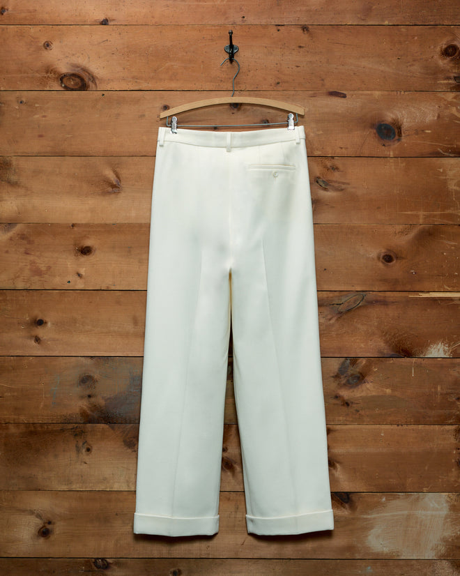 Off-white wide-leg Riding Twill McNab Trousers with a buttoned back pocket, hanging on a wooden hanger.