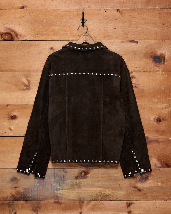 Studded Welding Jacket - Brown, displayed on a hanger against a wooden wall background.