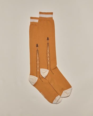 Geo Diamond Sock: Mustard yellow knee-high cotton socks with white toes, heels, and cuffs, featuring a black dotted geometric pattern for a vintage-inspired look.