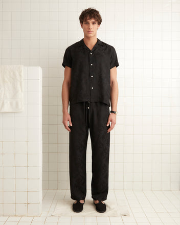 Black silk and viscose blend pajama pants with football player jacquard print with drawstring tie.