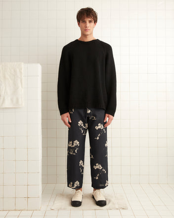 Black linen pajama pants, images of football players across the garment with drawstring tie at the waist.