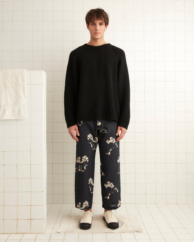 Black linen pajama pants, images of football players across the garment with drawstring tie at the waist.