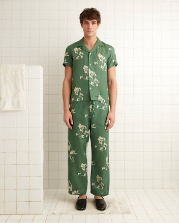 Green linen pajama pants, images of football players across the garment with drawstring tie at the waist.