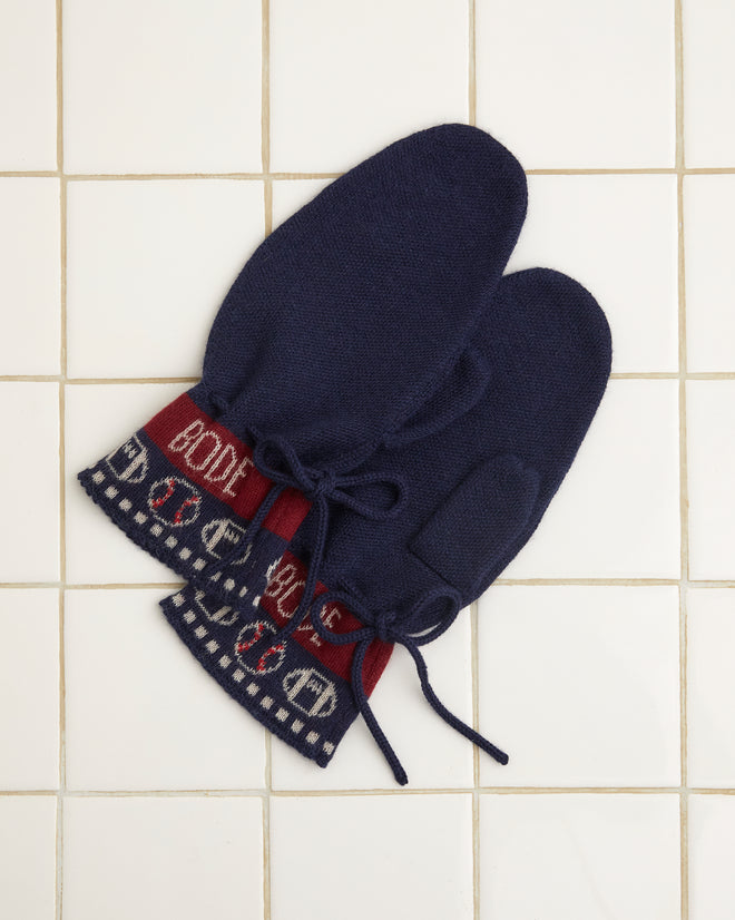 Sporting Jacquard Mittens in navy blue featuring red cuffs and a white pattern, crafted from soft baby alpaca, displayed on a white tiled surface.