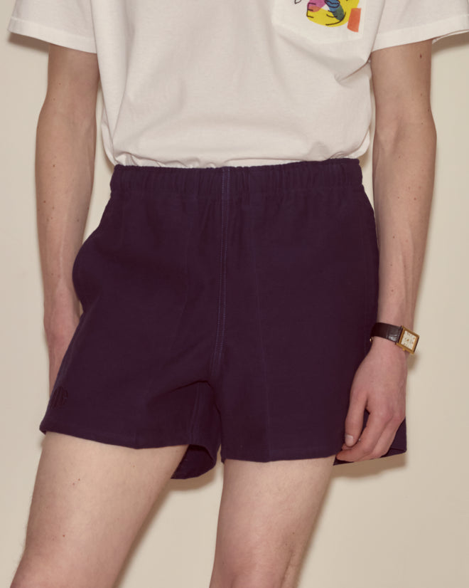 Person wearing a white t-shirt, Field Shorts - Navy made from heavyweight cotton twill, and a watch, standing against a plain background.