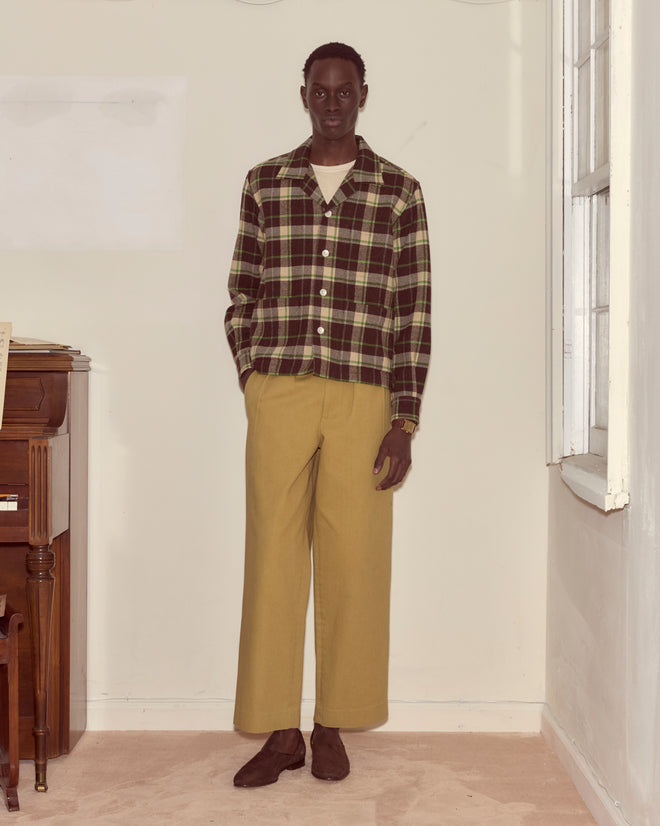 A person wearing the Woodcrest Overshirt, beige wide-leg pants, and brown shoes stands in a light-colored room.