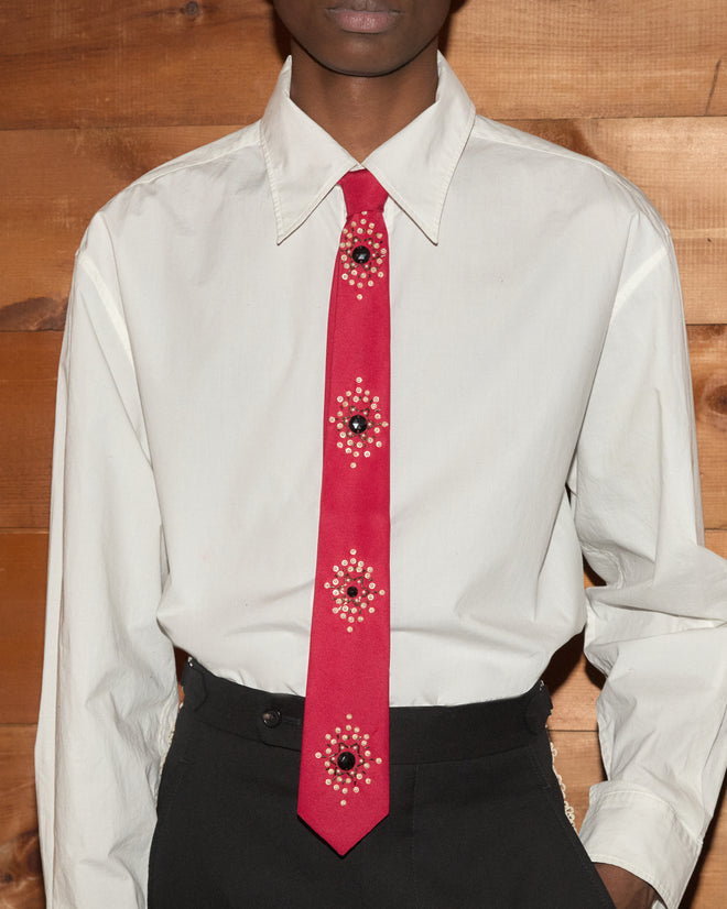 Luminaire Tie: red necktie with silver-tone floral bullion embroidery and crystal centers on a white button-down shirt.