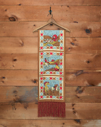 Cowboy Comic Scarf featuring three vintage farm animal panels and red fringe, displayed on a wooden wall with a hanger—perfect for adding a touch of cowboy comic charm to your space.