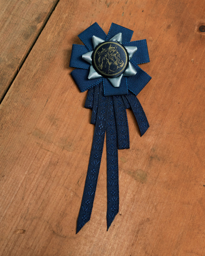 Horse Ribbon Brooch - Multi: blue equestrian prize ribbon brooch with a horse head emblem.