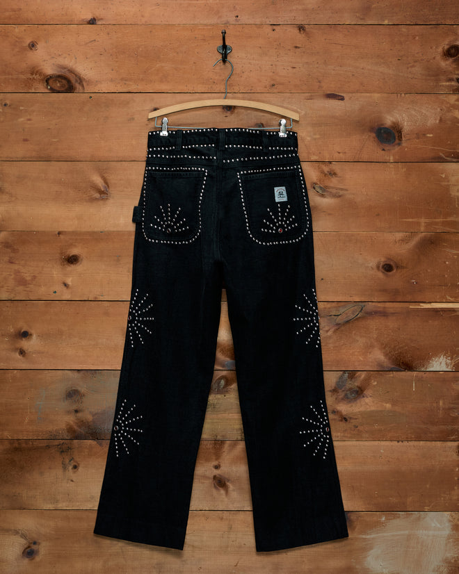 Silver Stud Knolly Brook cotton twill trousers with silver stud patterns on the back pockets and legs on a hanger.