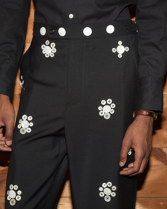Pearly Royal Side-Buckle Trousers: black trousers with antique-inspired, flower-shaped white pearl button clusters.