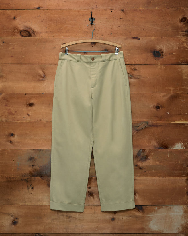 Campus Trousers - Khaki in cotton twill, with a button closure and cuffed hems on a wooden hanger.
