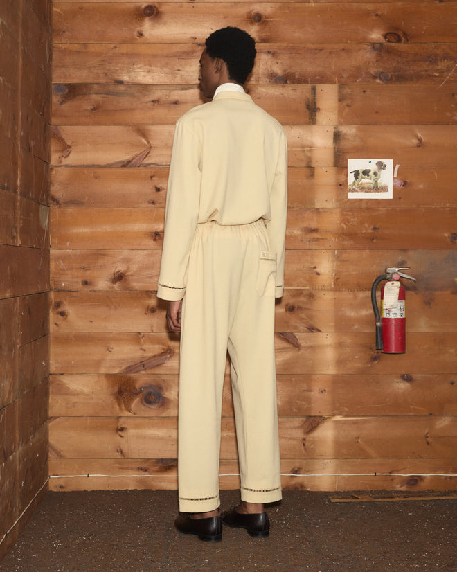 A person seen from behind wearing a cream-colored long-sleeved shirt and matching Ladder Crêpe Pajama Pants.