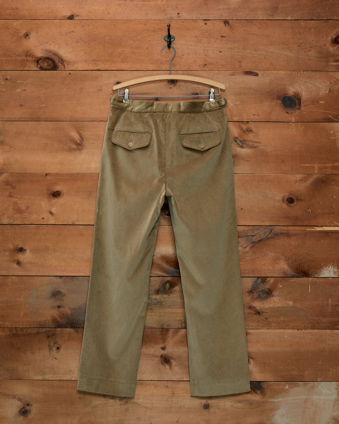 Corduroy Side-Buckle Trousers in tan corduroy with side-buckle adjusters and two buttoned back pockets on a hanger.