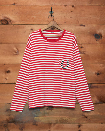 Rib Stripe Horseshoe Long Sleeve Tee, featuring red-and-white stripes, a chest pocket, and ribbed cotton fabric, displayed hanging on a wooden wall.