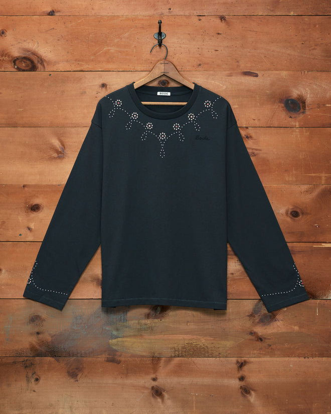 Silver Stud Long Sleeve Tee in black, featuring small white stud embellishments, displayed against a wooden wall background.