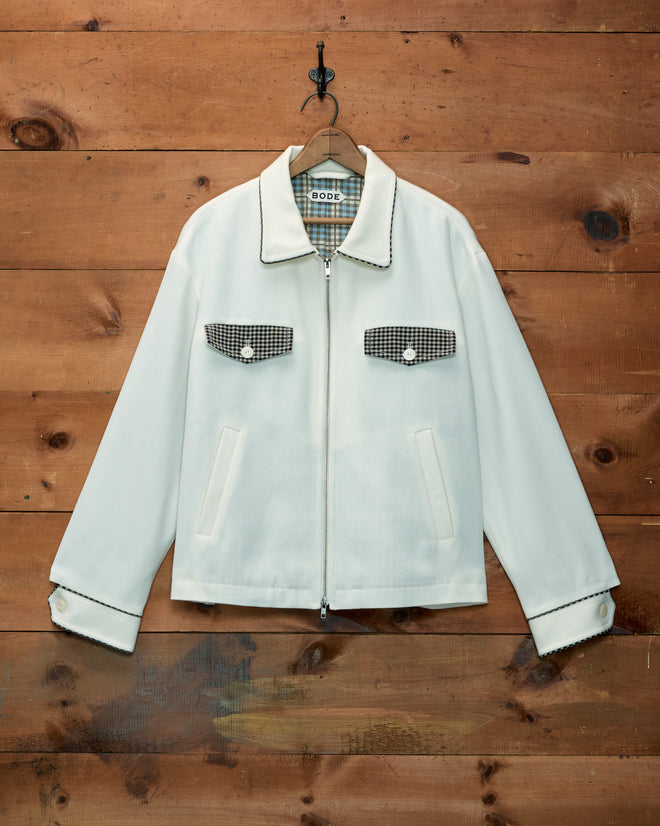 Stockton Jacket in off-white wool with a black and white checkered collar, pocket flaps, and cuffs.
