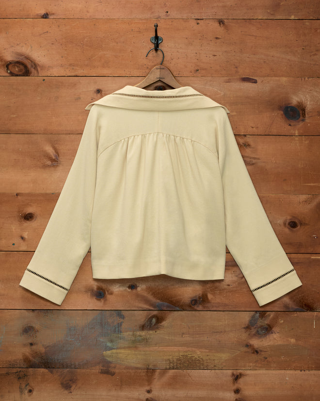 Back view of the pale yellow Ladder Crêpe Jacket with a collared neckline and ladder-stitch trim on the cuffs.