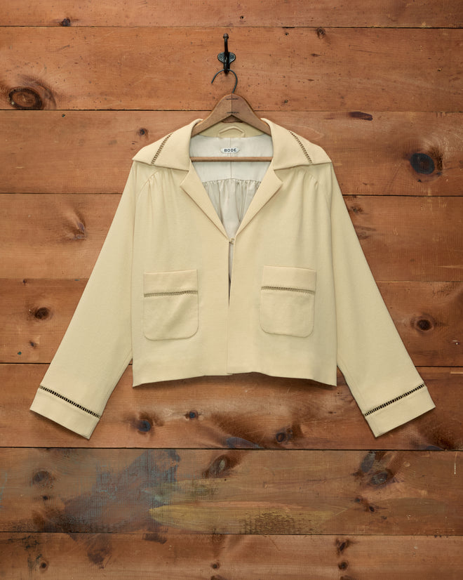 Cream-colored Ladder Crêpe Jacket featuring two front pockets and decorative ladder-stitch trim on cuffs and collar.