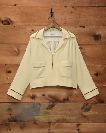 Cream-colored Ladder Crêpe Jacket featuring two front pockets and decorative ladder-stitch trim on cuffs and collar.