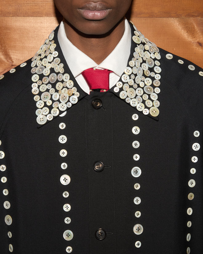 Pearly Royal Jacket featuring white buttons over a white shirt and red tie.