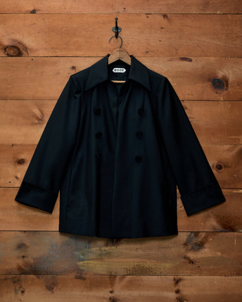 Sonora Mohair Jacket: an elongated black double-breasted jacket with wide lapels and buttoned cuffs on a hanger.