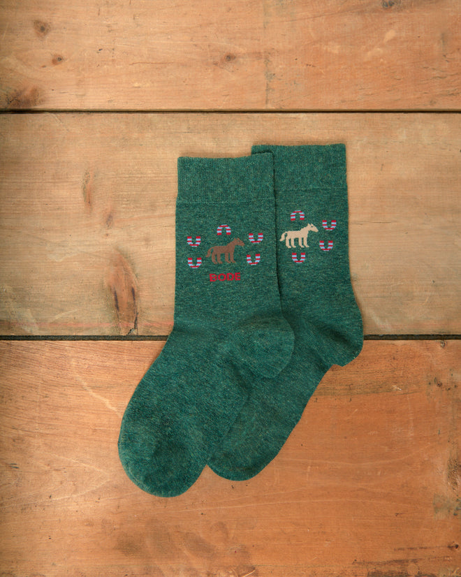Horseshoe Socks with small dog and bone patterns, laid flat on a wooden surface.