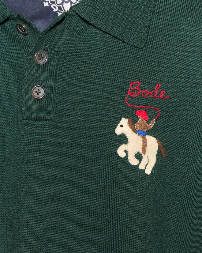 Cowboy Appliqué Polo - Green: Merino wool polo shirt in green with three buttons, featuring a cowboy-on-horse patch and red “Bode” hand-embroidered above it.