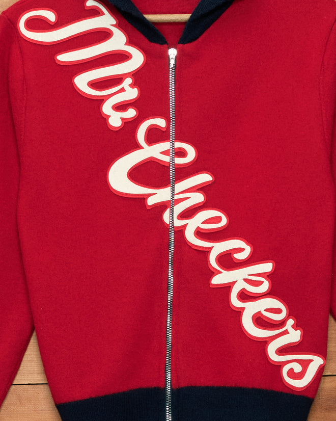 Mr. Checkers Felted Cardigan: A red zip-up cardigan made from 100% wool, featuring “Mr. Checkers” written diagonally across the front in large white cursive letters.