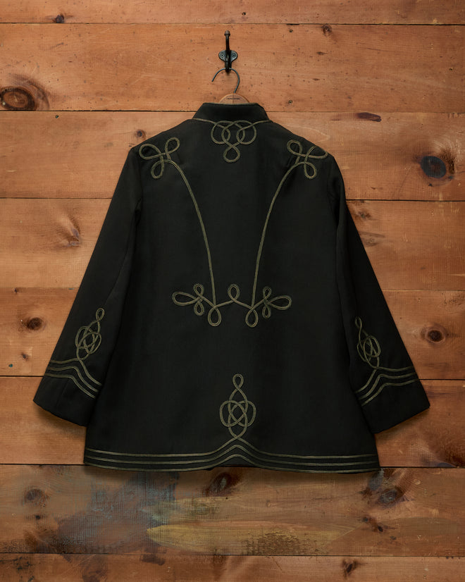 Cavalry Coat in black wool with decorative gold-colored soutache trim.