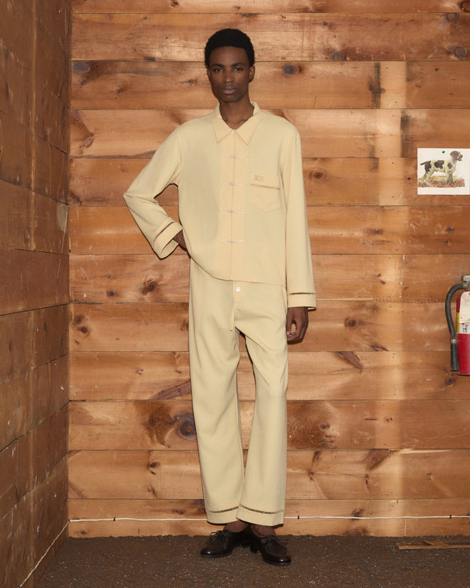 A person wearing a pale yellow, long-sleeved Ladder Crêpe Shirt and matching trousers.