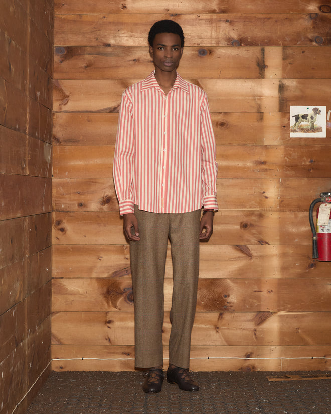 Person wearing a Rancho Long Sleeve Shirt and brown pants stands against wooden panel walls near a fire extinguisher.