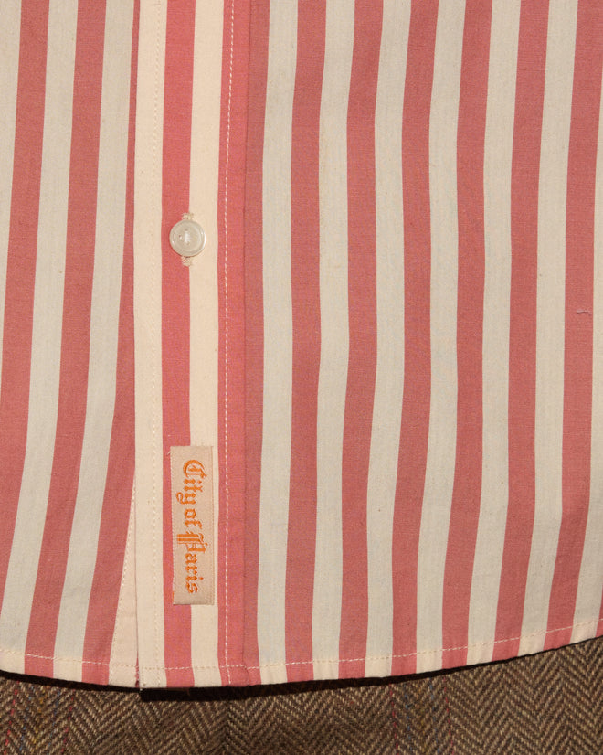A Rancho Long Sleeve Shirt with vertical pink and white stripes, crafted from 100% cotton and made in India, features a button and a “City of Stars” label above plaid pants.