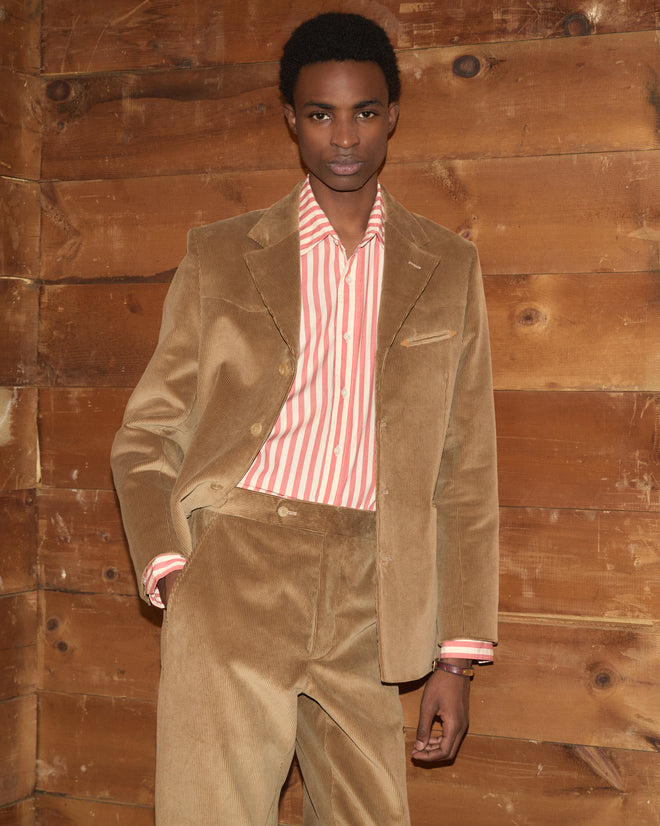 A person wearing a Western Corduroy Suit Jacket in tan with matching trousers over a striped button-down shirt.