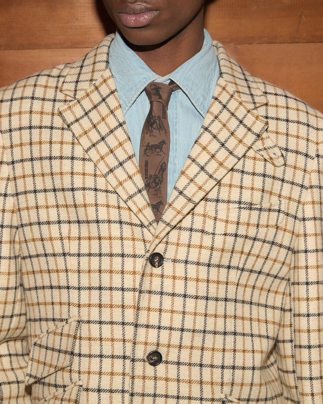 Sandhill Plaid Hacking Jacket in tan over a light blue button-down shirt and a horse-drawn carriage print brown tie.