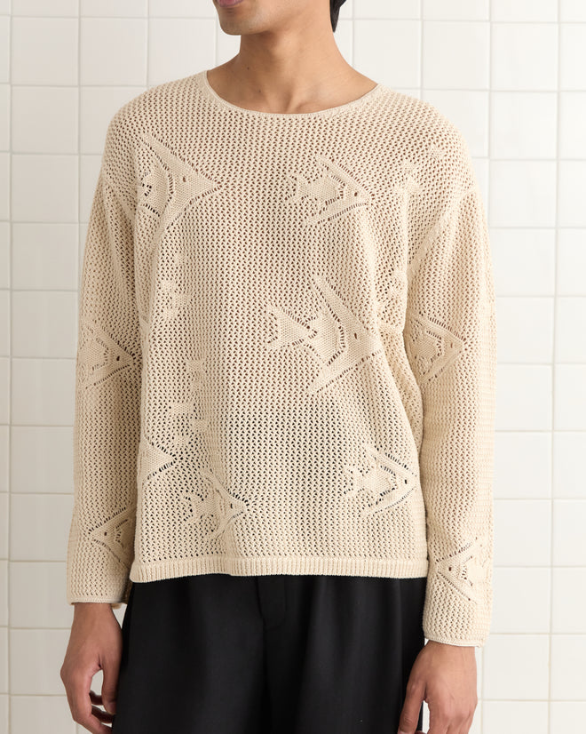 An individual in an Angel Fish Pullover featuring delicate star patterns is standing against a tiled wall.