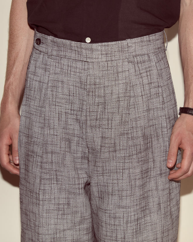 A person wearing Static Weave McNab Trousers in high rise gray weave and a dark shirt, shown from waist to mid-thigh.